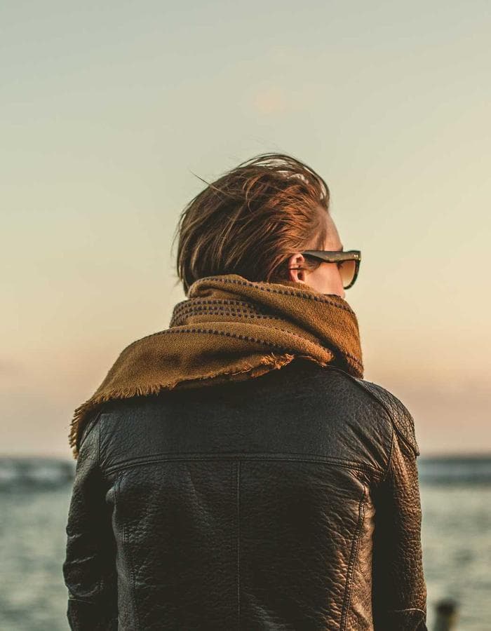Figure facing the sunset over the water