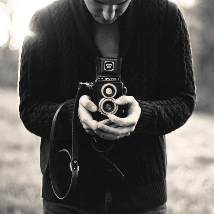 Photographer holding a vintage camera, black and white